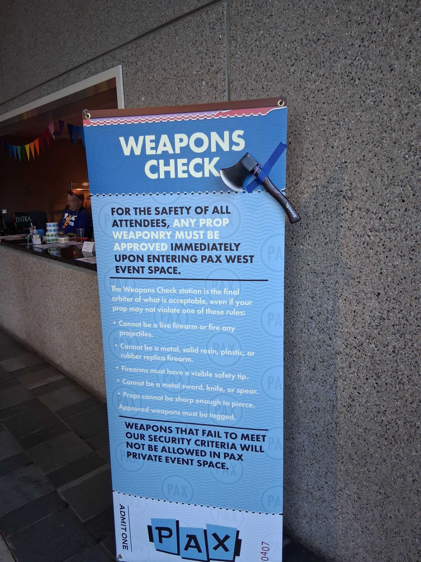 A Voidwood foam axe taped to a PAX West weapons check sign