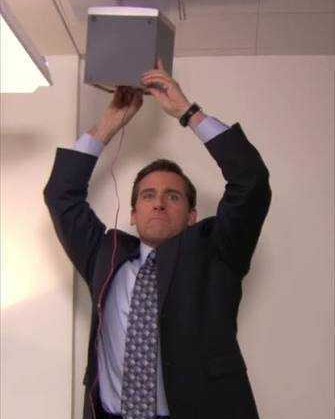 Michael Scott holding a speaker above his head in The Office